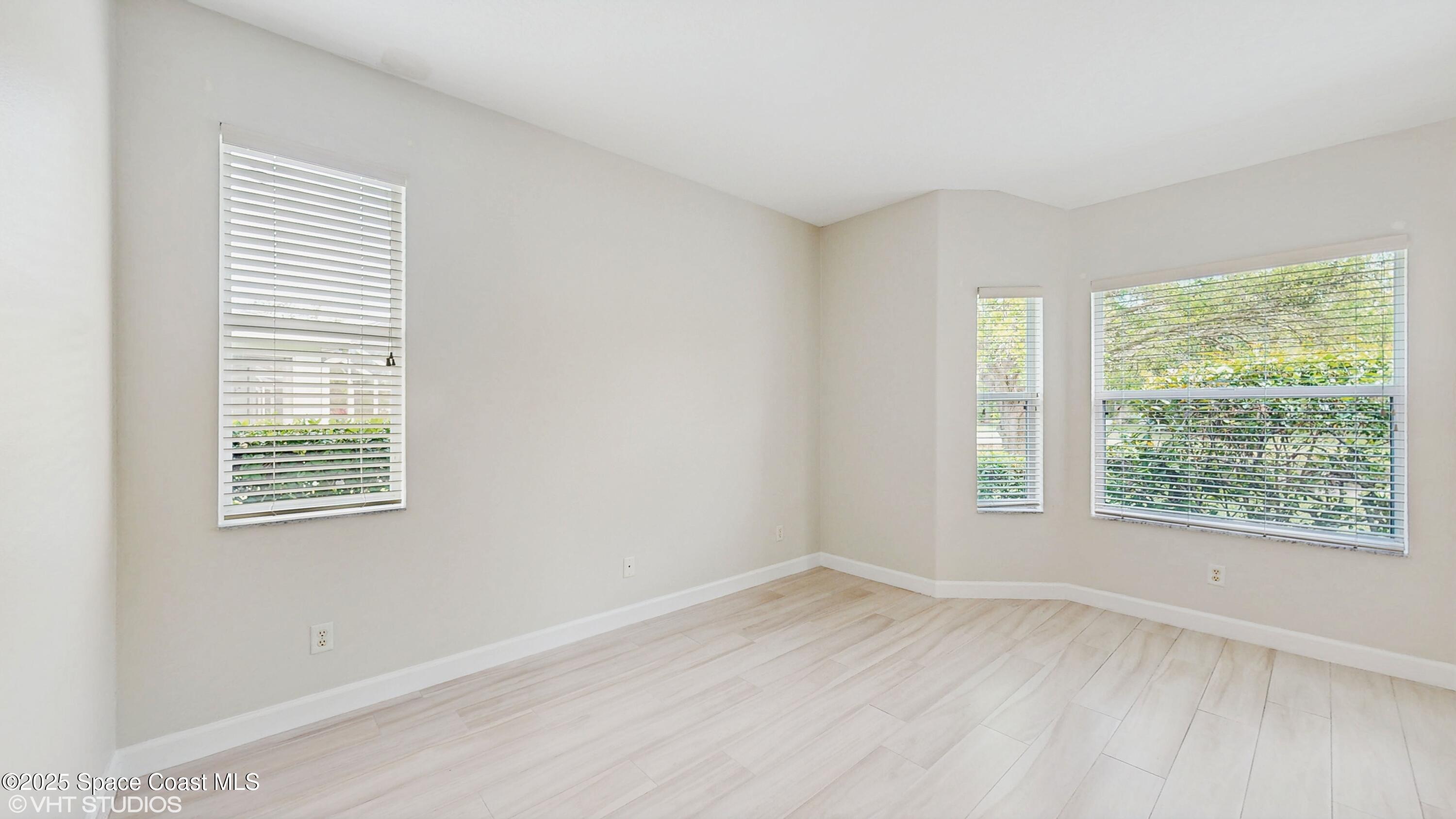 652 Hatteras Court Southwest Vero Beach, FL 32968 - Photo 15 of 48 a view of an empty room with wooden floor and a window