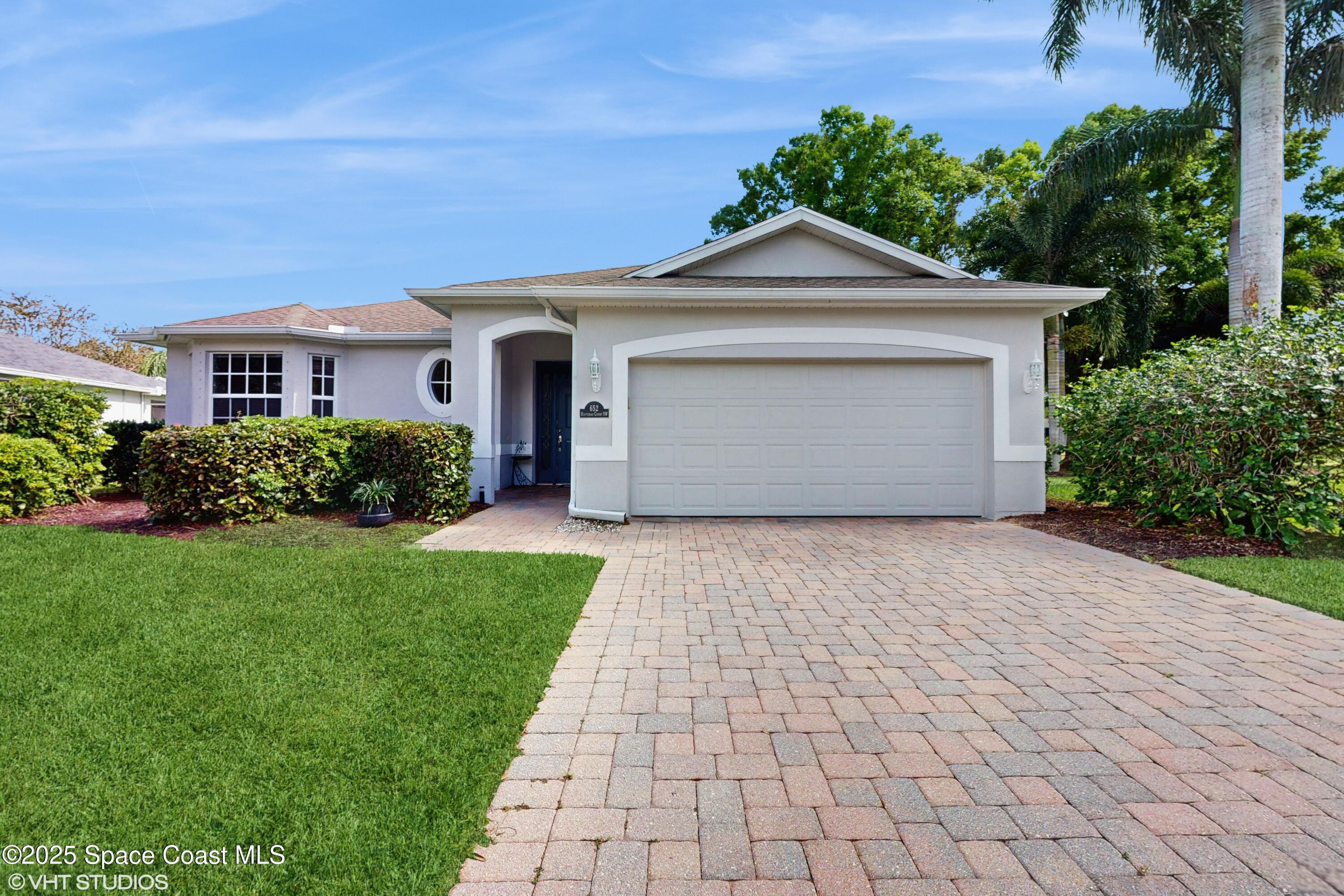 652 Hatteras Court Southwest Vero Beach, FL 32968 - Photo 3 of 48 a front view of a house with a yard and garage
