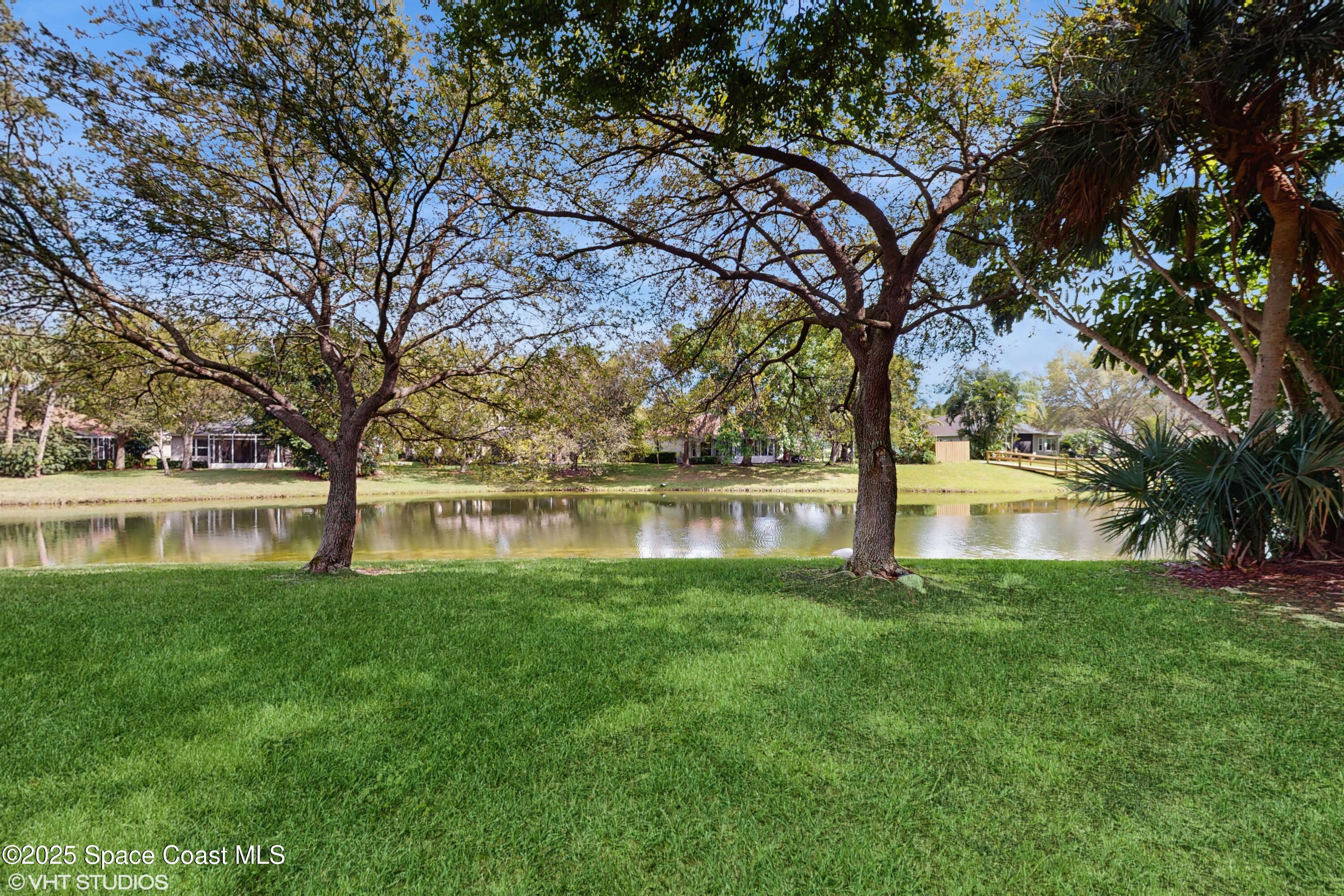 652 Hatteras Court Southwest Vero Beach, FL 32968 - Photo 32 of 48 a backyard of a house with lots of green space and fountain