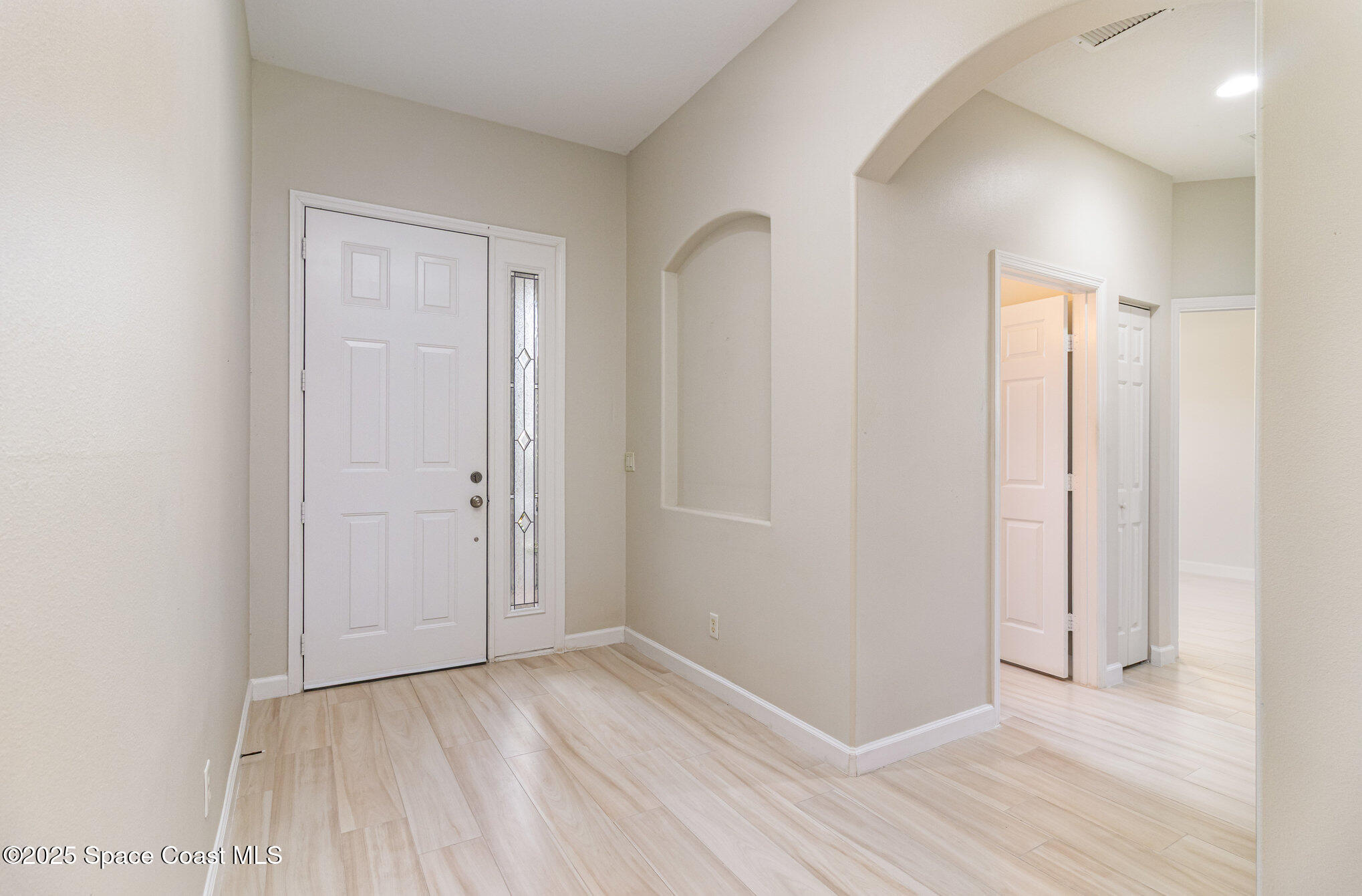 652 Hatteras Court Southwest Vero Beach, FL 32968 - Photo 5 of 48 an empty room with wooden floor and windows