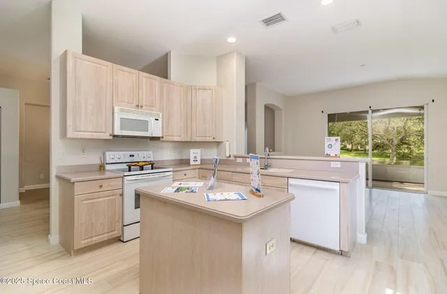 a kitchen with appliances a sink and cabinets