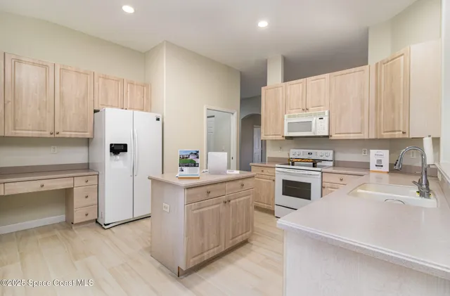 a kitchen with white cabinets and white appliances