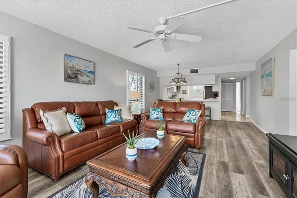 a living room with furniture kitchen view and a chandelier