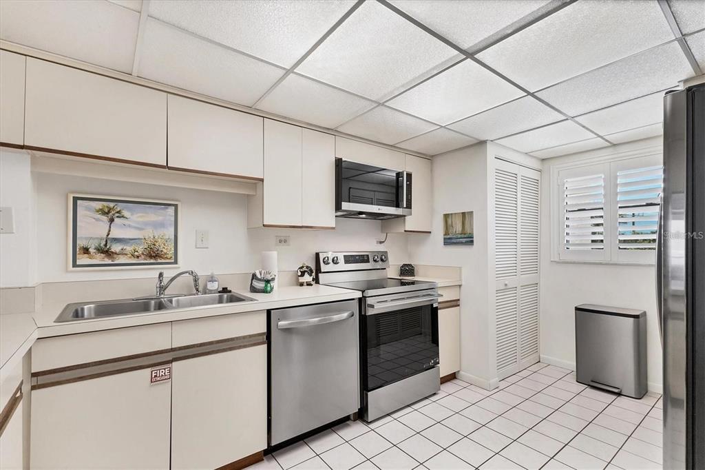 6480 Midnight Pass Road, Unit 311 Sarasota, FL 34242 - Photo 18 of 48 a kitchen with a sink cabinets and stainless steel appliances