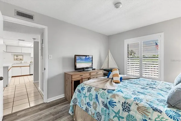 a bedroom with a bed and wooden floor