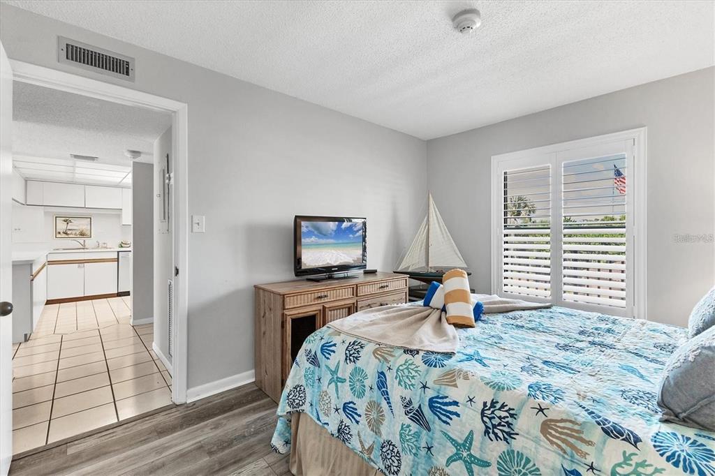 6480 Midnight Pass Road, Unit 311 Sarasota, FL 34242 - Photo 28 of 48 a bedroom with a bed and wooden floor