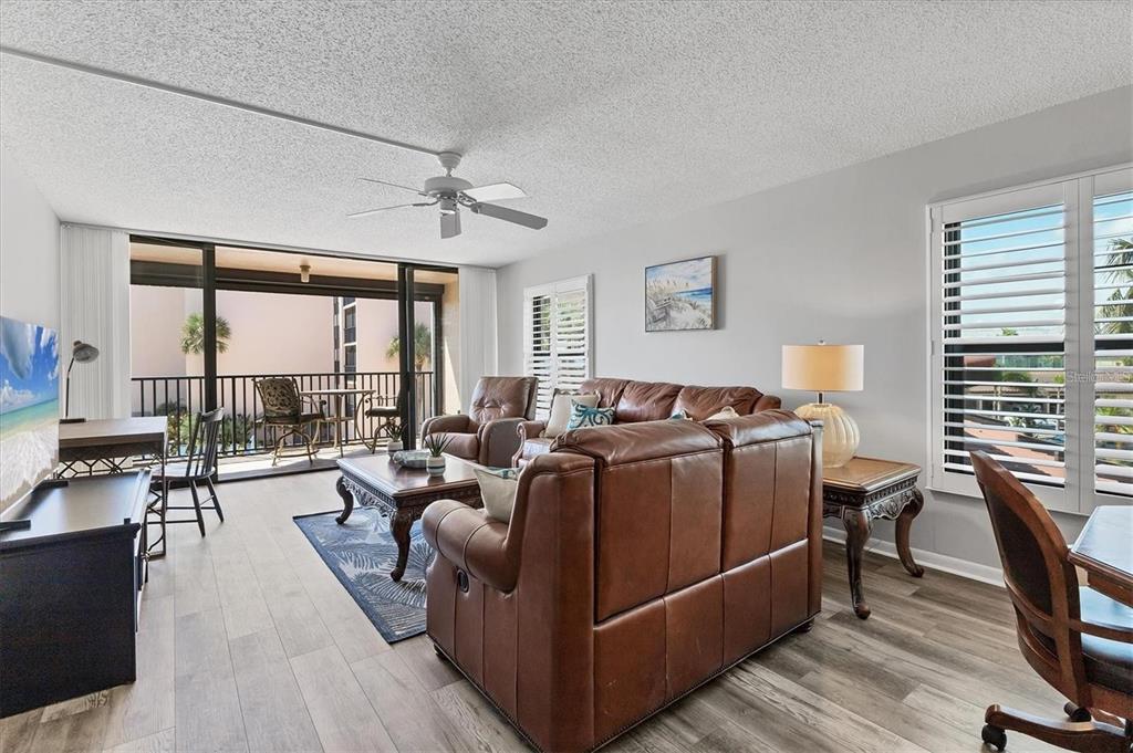 6480 Midnight Pass Road, Unit 311 Sarasota, FL 34242 - Photo 3 of 48 a living room with furniture a large window and wooden floor