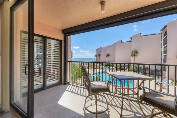 a balcony with wooden floor table and chairs
