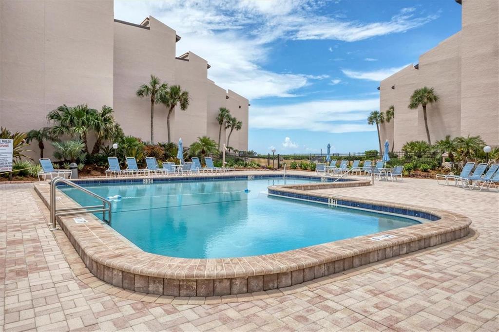 6480 Midnight Pass Road, Unit 311 Sarasota, FL 34242 - Photo 36 of 48 a view of a swimming pool with a lawn chairs