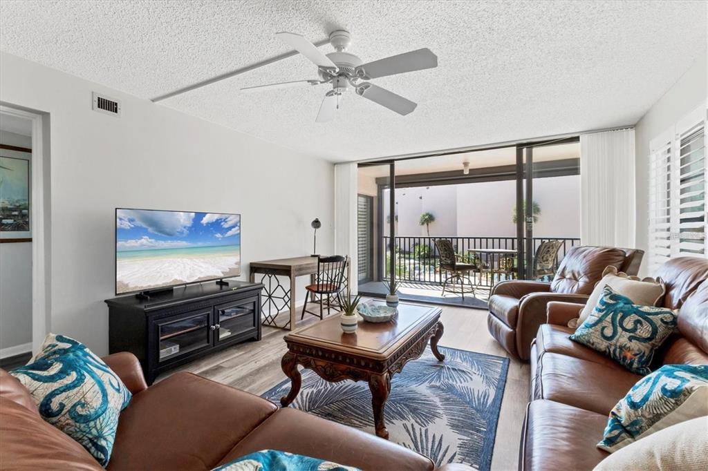6480 Midnight Pass Road, Unit 311 Sarasota, FL 34242 - Photo 10 of 48 a living room with furniture and a flat screen tv