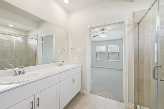 a bathroom with a double vanity sink mirror and shower