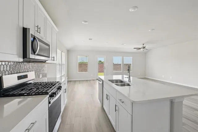 a kitchen with stainless steel appliances a sink stove and cabinets
