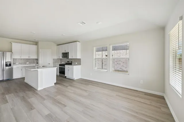a view of kitchen with wooden floor and electronic appliances