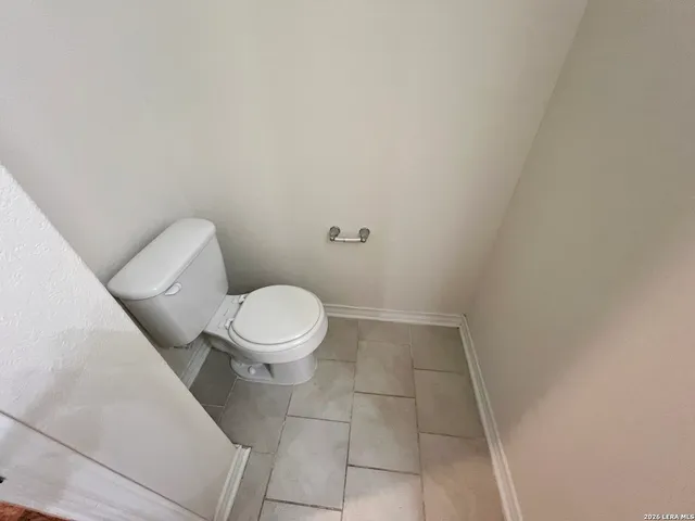 an empty room with a chandelier fan and windows