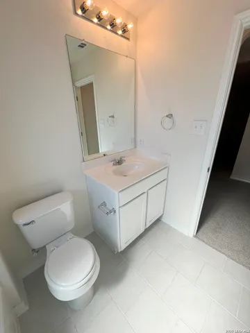 an empty room with windows and chandelier fan