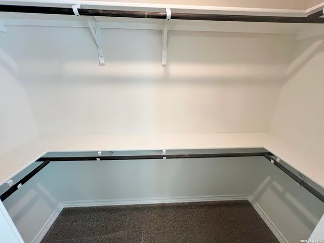 an empty room with windows and chandelier fan