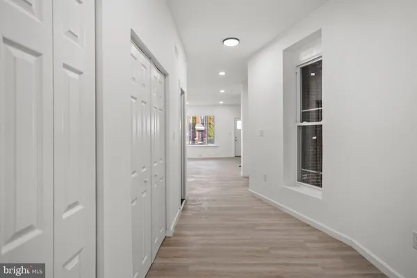 a view of a hallway with wooden floor and staircase