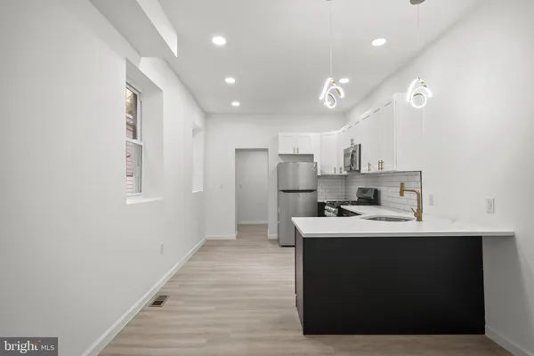 a kitchen with kitchen island a sink stainless steel appliances and cabinets