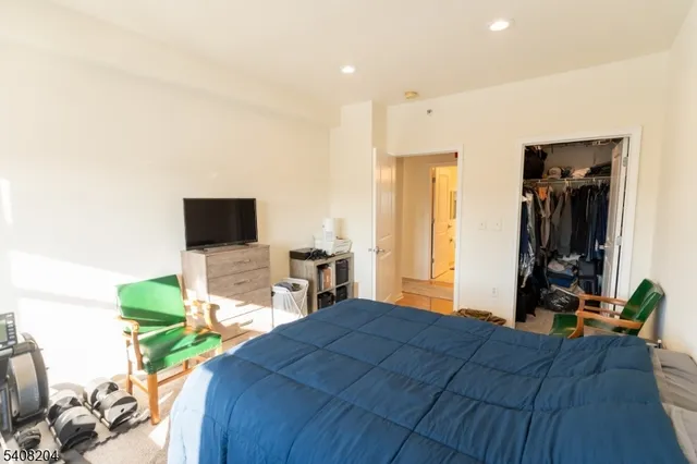 a bedroom with a bed and a flat tv screen on dresser