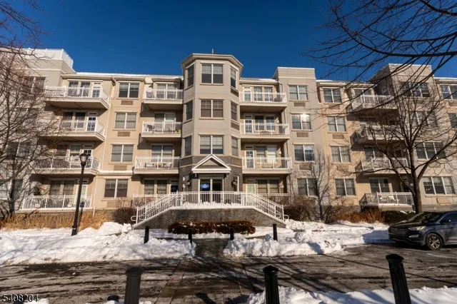 a front view of a building with streets and trees