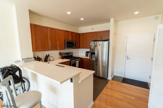 a kitchen with a refrigerator a stove top oven a sink and cabinets