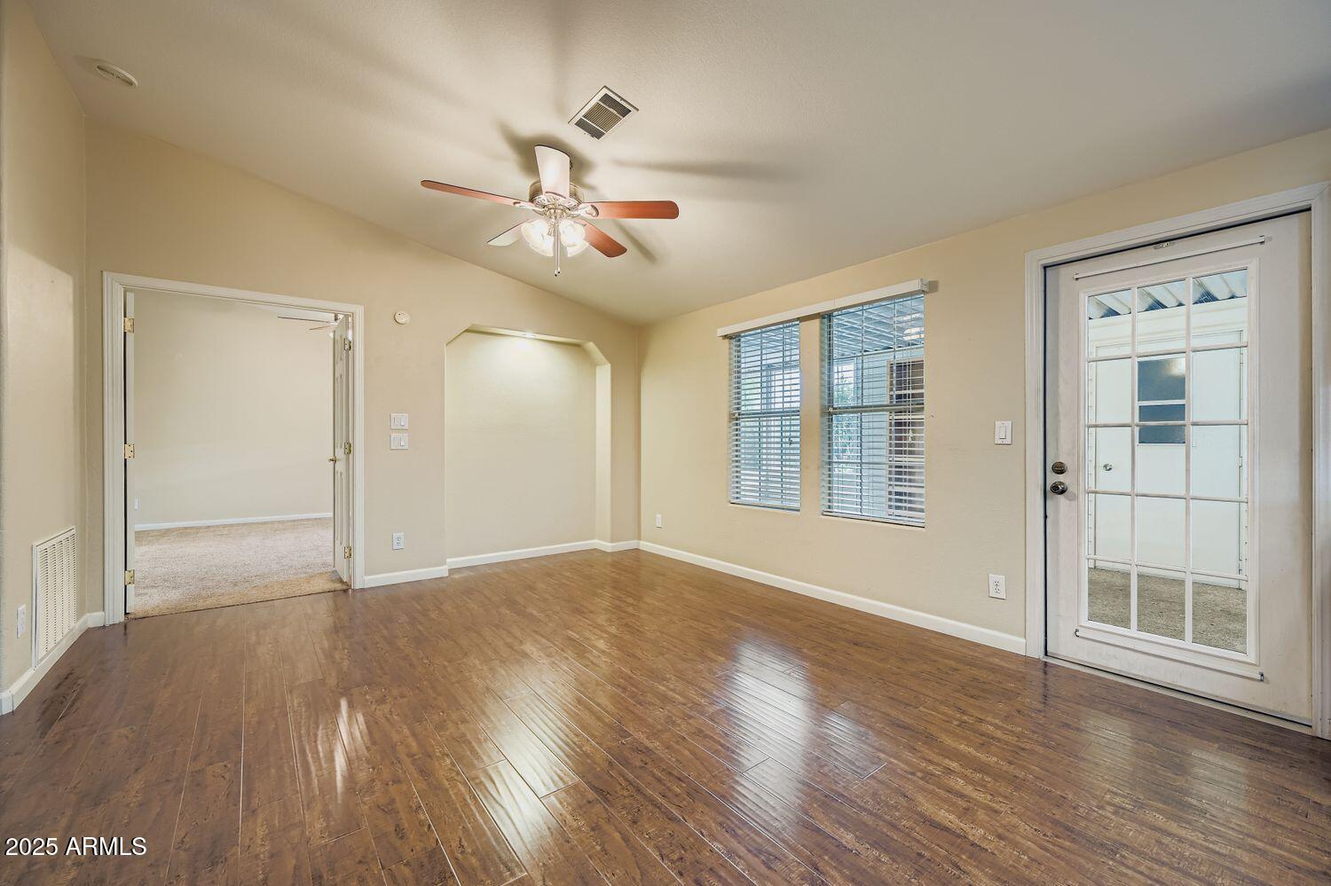 2550 South Ellsworth Road, Unit 277 Mesa, AZ 85209 - Photo 10 of 20 a view of an empty room with a window and wooden floor