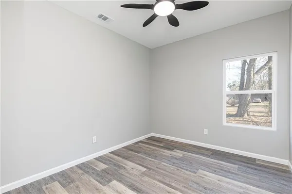 an empty room with a window and a ceiling fan