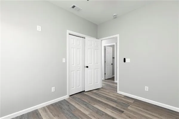 a view of an empty room with wooden floor