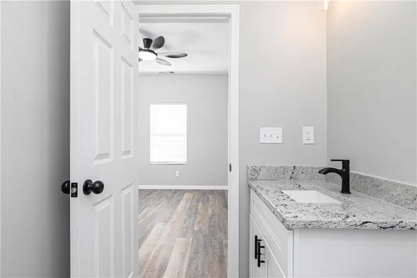 a bathroom with a granite countertop sink and a mirror