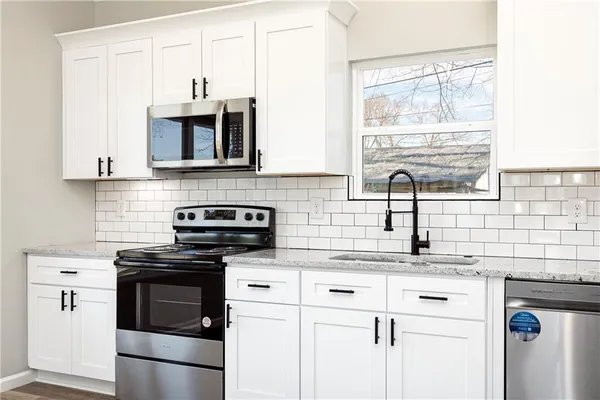 a kitchen with appliances cabinets and a sink