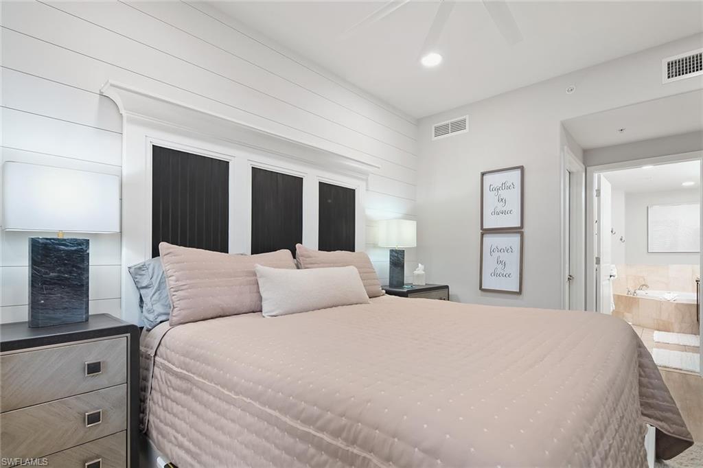 1015 Sandpiper Street, Unit D102 Naples, FL 34102 - Photo 15 of 34 a bedroom with a large bed and painting on the wall