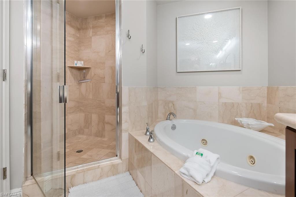 1015 Sandpiper Street, Unit D102 Naples, FL 34102 - Photo 17 of 34 a bathroom with a bathtub and shower