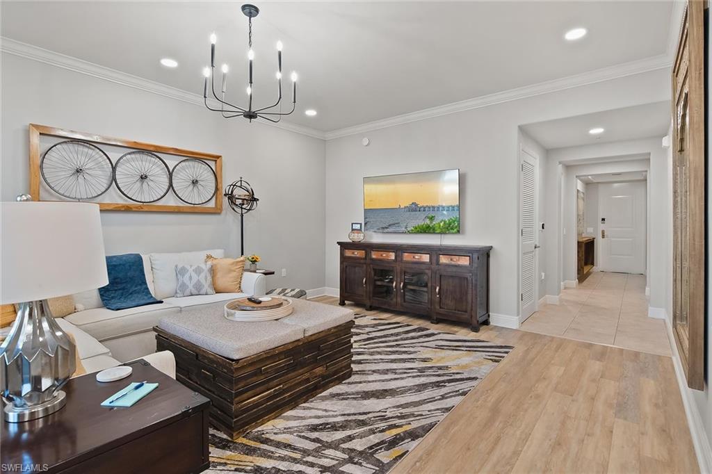 1015 Sandpiper Street, Unit D102 Naples, FL 34102 - Photo 3 of 34 a living room with furniture and a chandelier