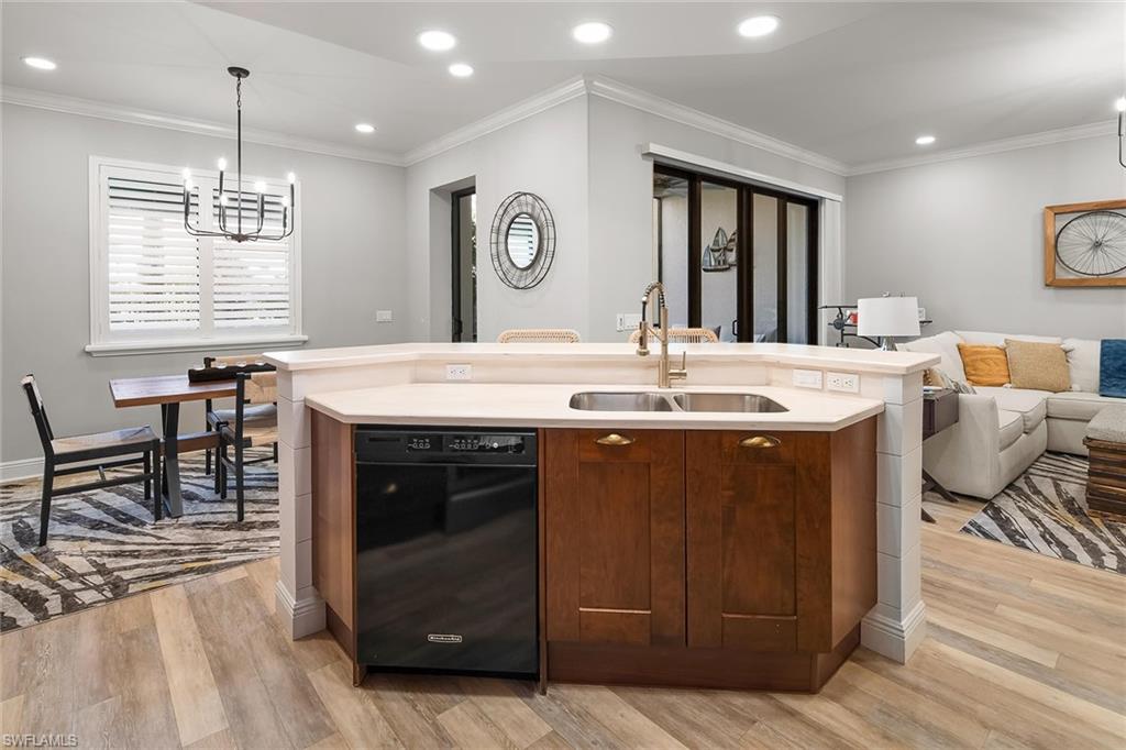 1015 Sandpiper Street, Unit D102 Naples, FL 34102 - Photo 8 of 34 a large kitchen with granite countertop a stove and a wooden floor
