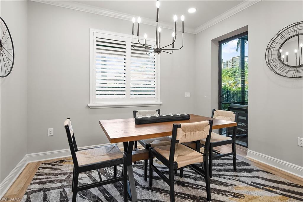1015 Sandpiper Street, Unit D102 Naples, FL 34102 - Photo 9 of 34 a view of a dining room with furniture window and wooden floor