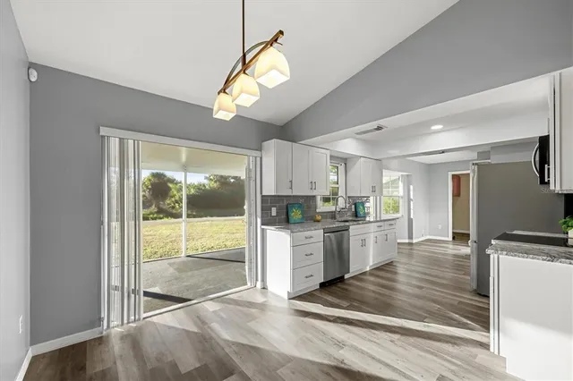 a large kitchen with cabinets and wooden floor