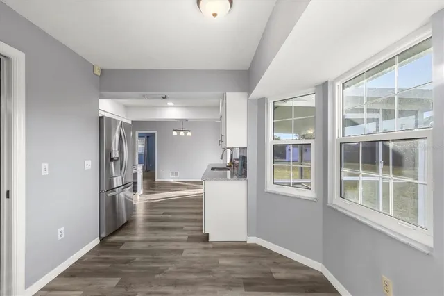 a view of a hallway with wooden floor and windows