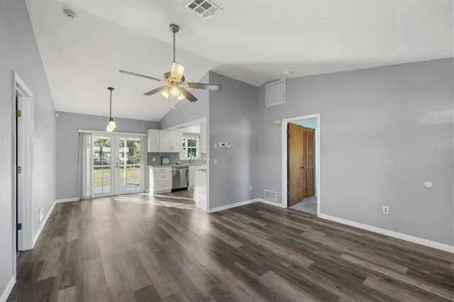 a view of a kitchen with a kitchen island wooden floor and a ceiling fan