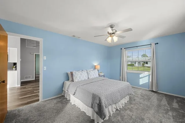 a bedroom with a balcony a large bed and a chandelier fan