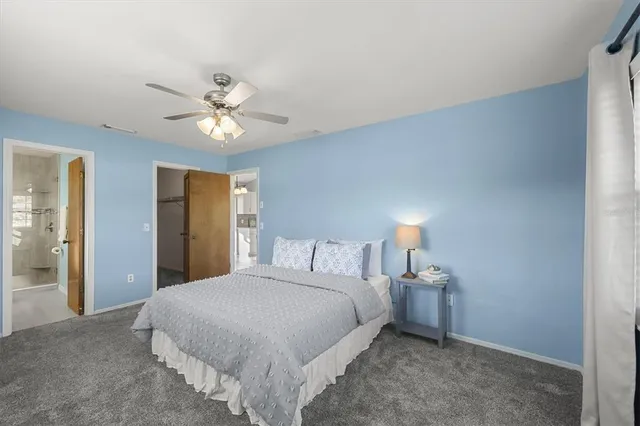 a bedroom with a bed and a ceiling fan