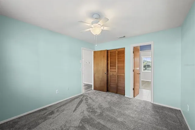 a view of a livingroom with a ceiling fan and window