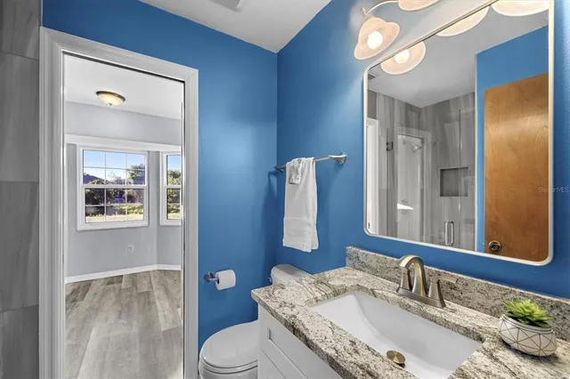 a bathroom with a granite countertop sink and a mirror