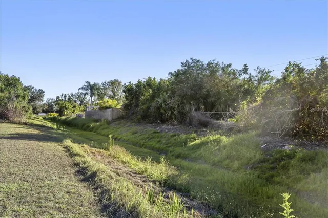a front view of house with yard and lake view in back