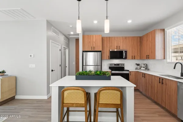 a kitchen with microwave a sink and chairs