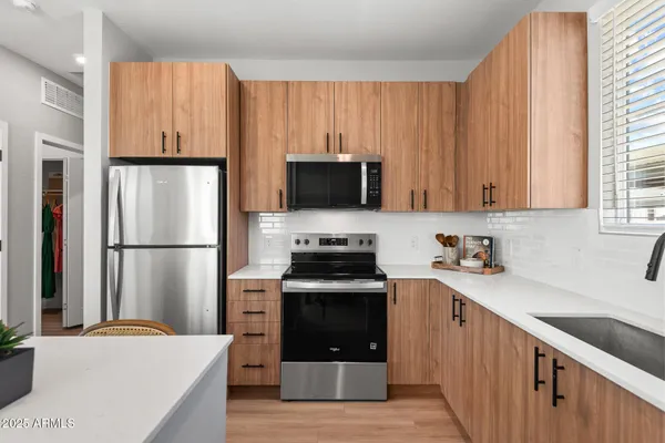 a kitchen with a stove refrigerator and microwave