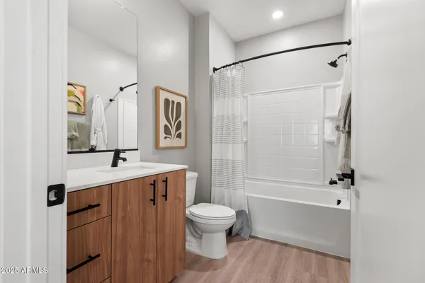 a bathroom with a bathtub shower sink mirror and toilet