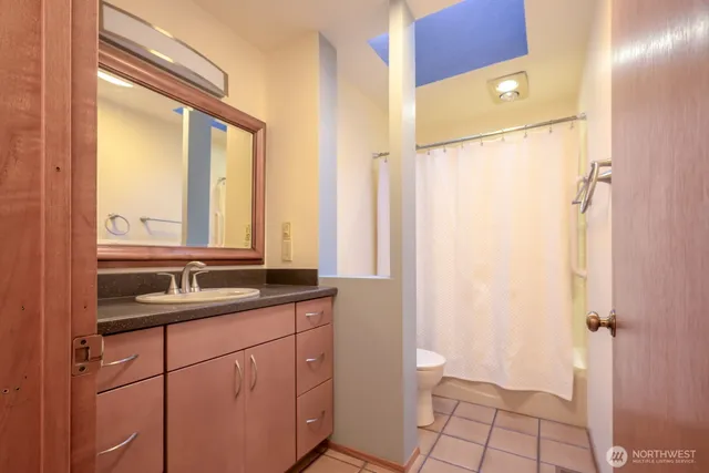 a bathroom with a granite countertop sink toilet and shower