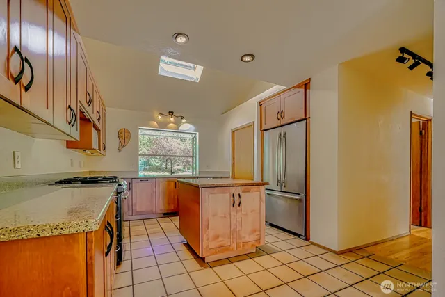 a kitchen with stainless steel appliances granite countertop a refrigerator and a stove