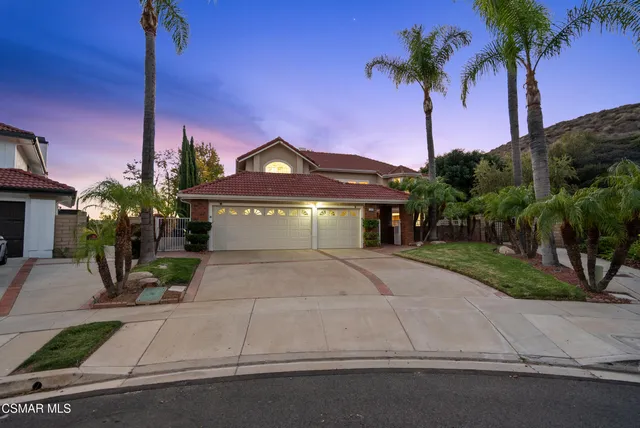 a front view of a house with a yard and potted plants