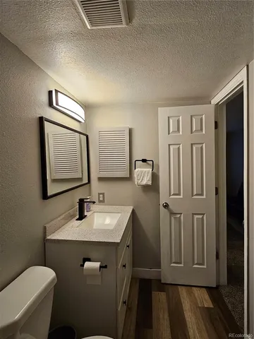 a bathroom with a sink a toilet a mirror and shower